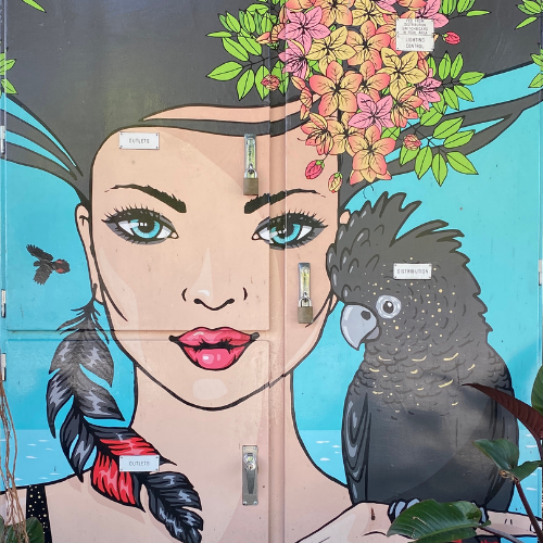 street art image of woman with black cockatoo on her shoulder